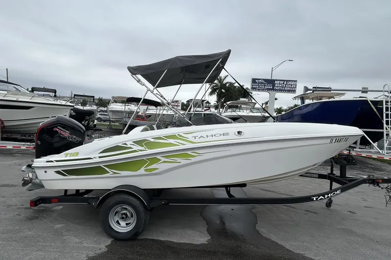 Slide: The Image of 2022 Tahoe T18 boat with canopy on trailer in marina setting. - 30