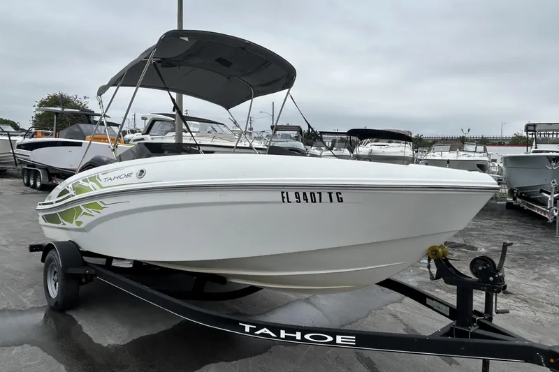 Slide: The Image of 2022 Tahoe T18 boat on trailer, parked in a marina with overcast skies. - 31