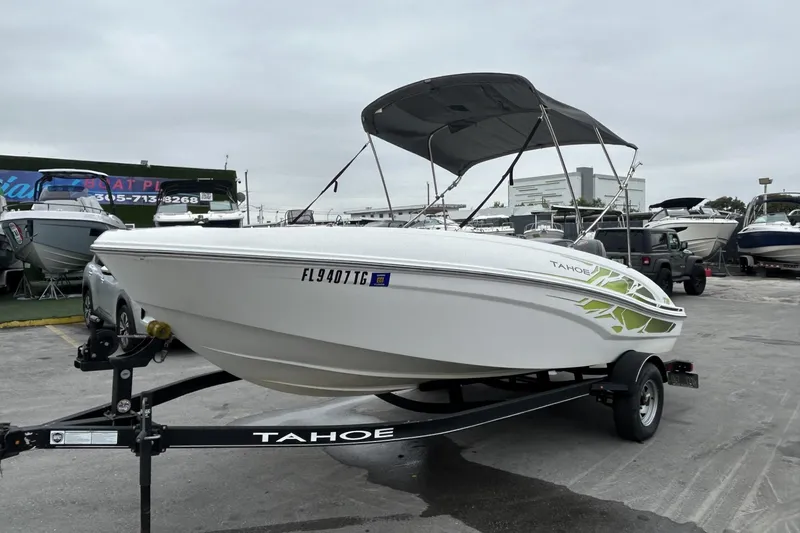 Slide: The Image of 2022 Tahoe T18 boat on trailer with canopy, parked in a marina. - 32