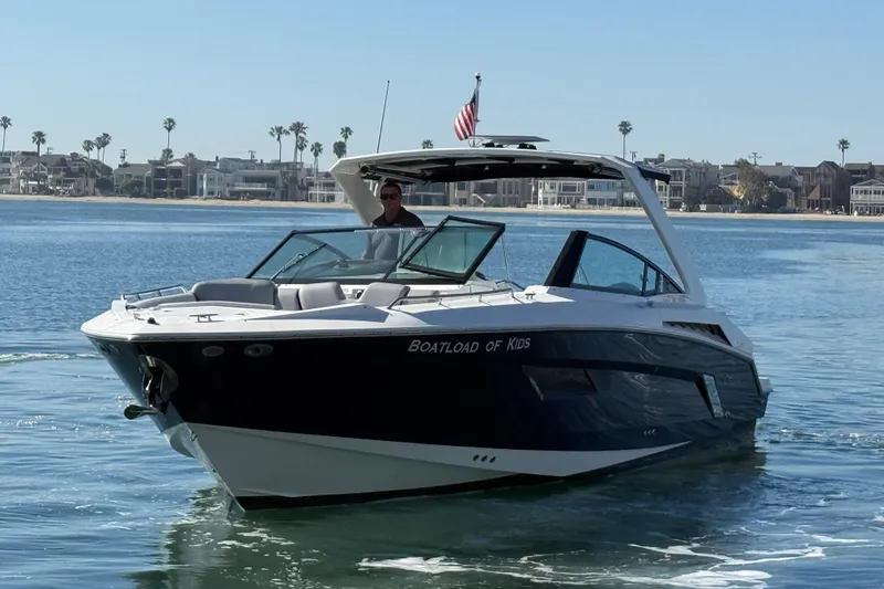 The Image of 2015 Cruisers Yachts 338 Bow Rider on calm water, coastal homes in background. - 0