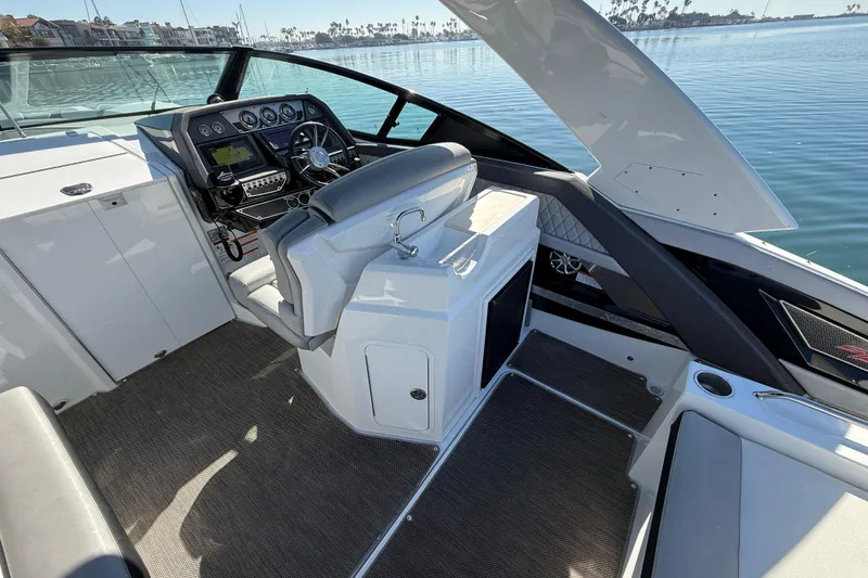 Slide: The Image of 2015 Cruisers Yachts 338 Bow Rider cockpit with modern controls and waterfront view. - 10