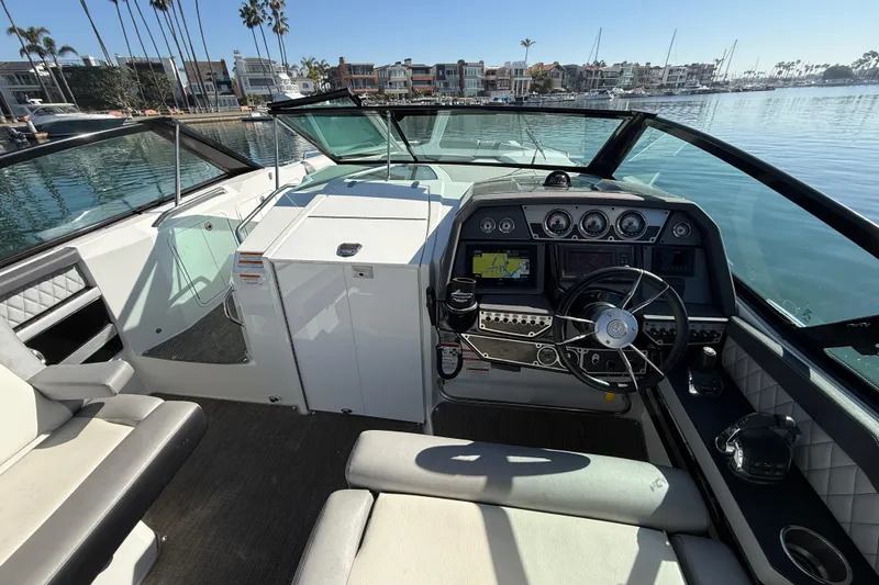 Slide: The Image of 2015 Cruisers Yachts 338 Bow Rider helm with modern controls and waterfront view. - 6