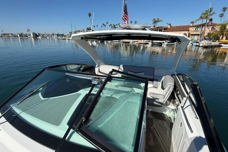 Slide: The Image of 2015 Cruisers Yachts 338 Bow Rider on calm water, showcasing sleek design and spacious seating. - 8