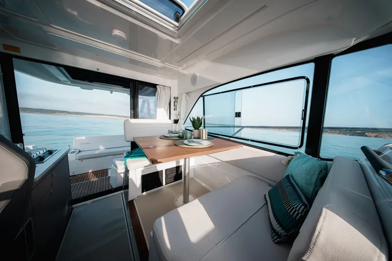 Slide: The Image of 2025 Beneteau Antares 9 interior with modern seating and ocean view. - 21