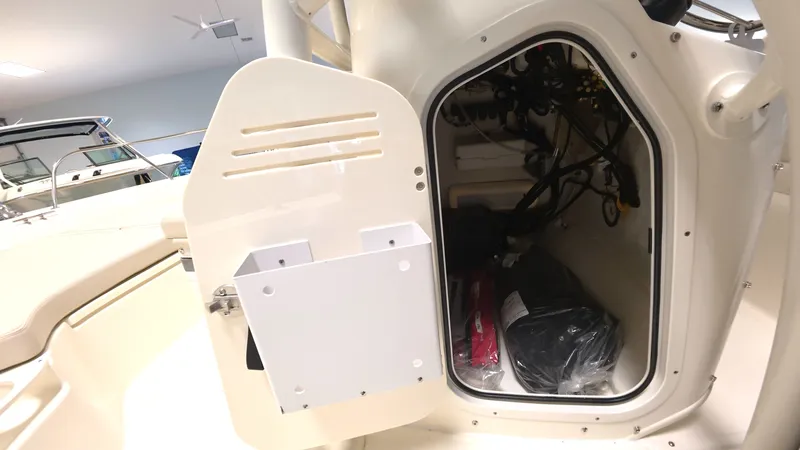 Slide: The Image of An open storage compartment on a Boston Whaler 190 Montauk boat, showing equipment and cables. - 12