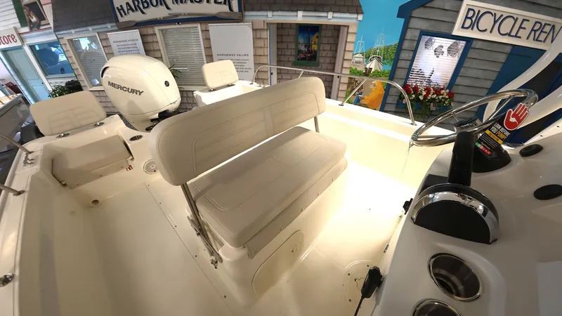 Slide: The Image of Interior of a Boston Whaler 190 Montauk with beige cushioned seating and a helm console. - 9