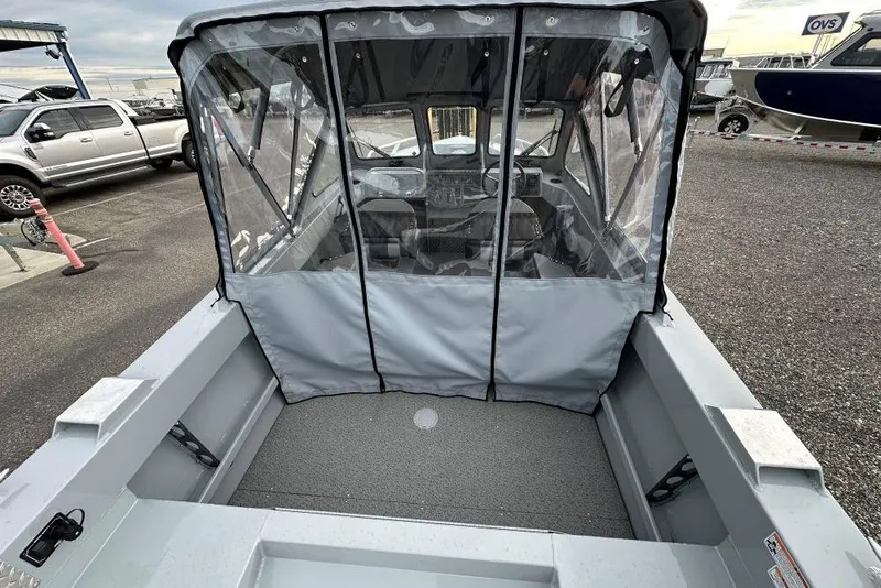 Slide: The Image of 2026 Hewescraft 160 Sportsman boat with enclosed cabin, parked outdoors. - 2