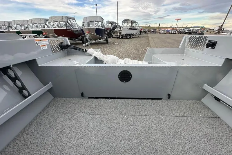 Slide: The Image of 2026 Hewescraft 160 Sportsman boat interior with gray flooring and storage compartments. - 6