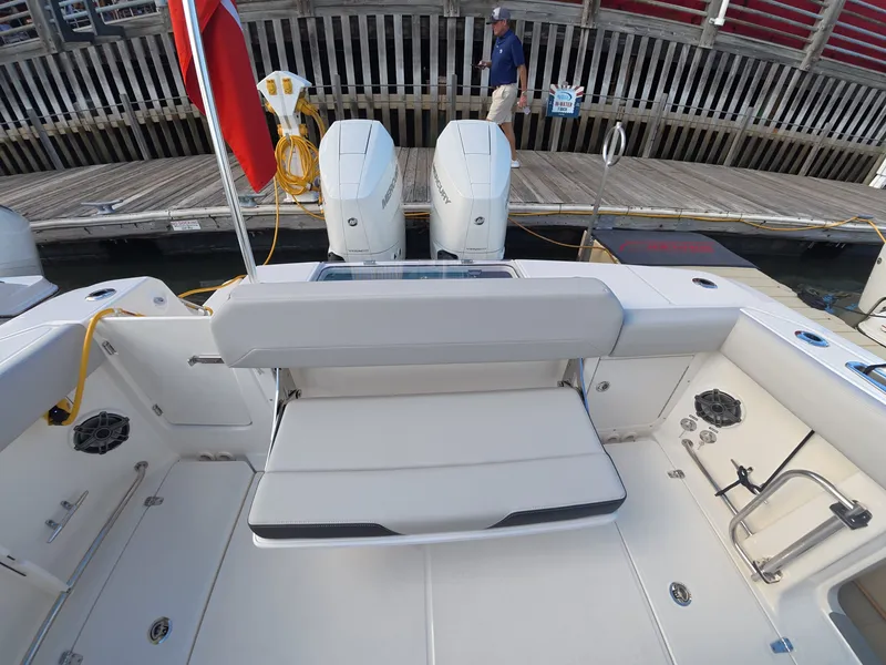 Slide: The Image of The image shows the stern of a Boston Whaler 330 Outrage with dual engines and a bench seat. - 9