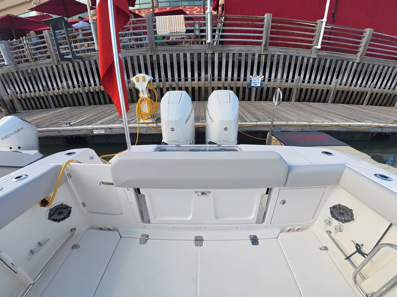 Slide: The Image of The image shows the stern of a Boston Whaler 330 Outrage with two outboard engines at a dock. - 4