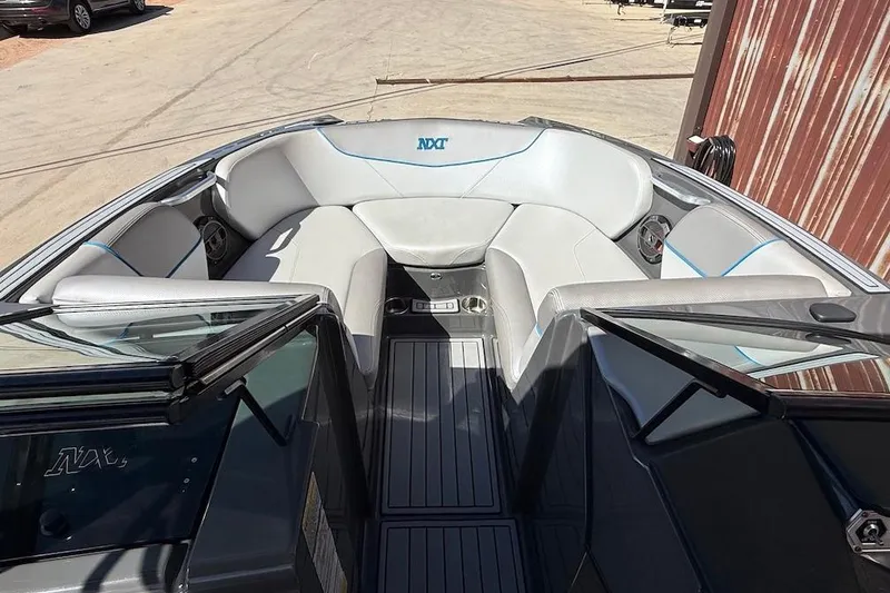 Slide: The Image of 2018 MasterCraft NXT22 boat interior with gray seating and blue accents. - 13