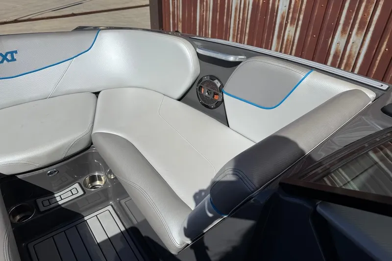 Slide: The Image of 2018 MasterCraft NXT22 boat interior with gray seating and blue accents. - 15