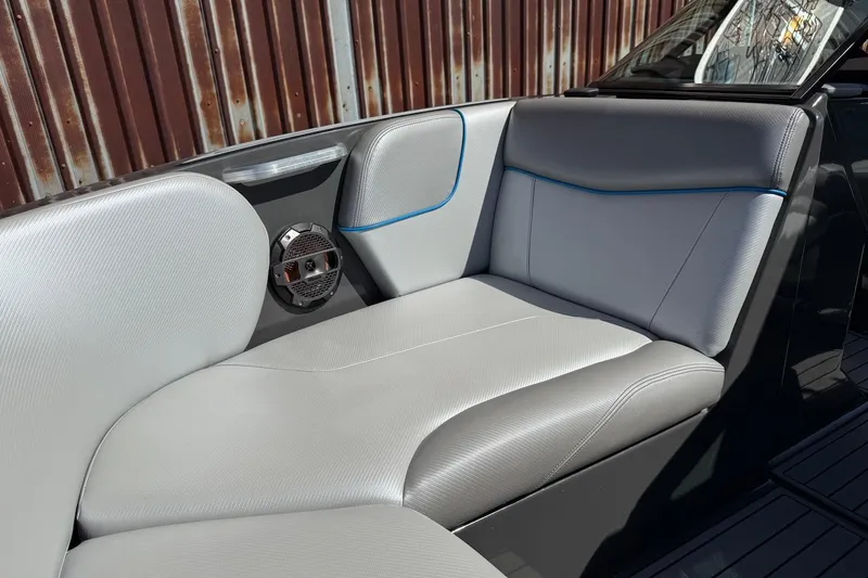 Slide: The Image of 2018 MasterCraft NXT22 boat interior with gray seating and speaker detail. - 16
