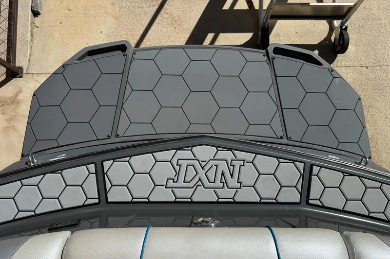 Slide: The Image of 2018 MasterCraft NXT22 boat deck with hexagonal pattern and "DXN" logo. - 4