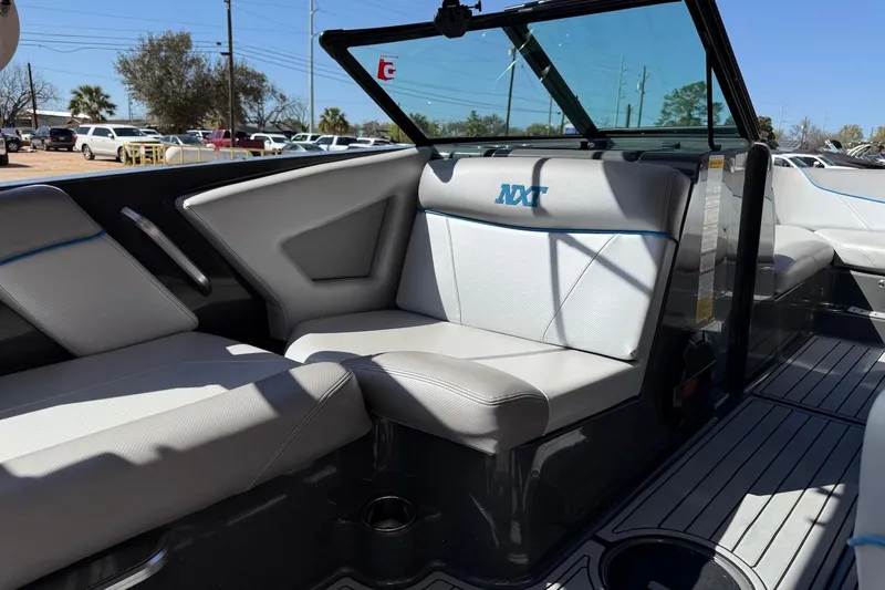 Slide: The Image of 2018 MasterCraft NXT22 boat interior with gray seating and blue accents. - 8