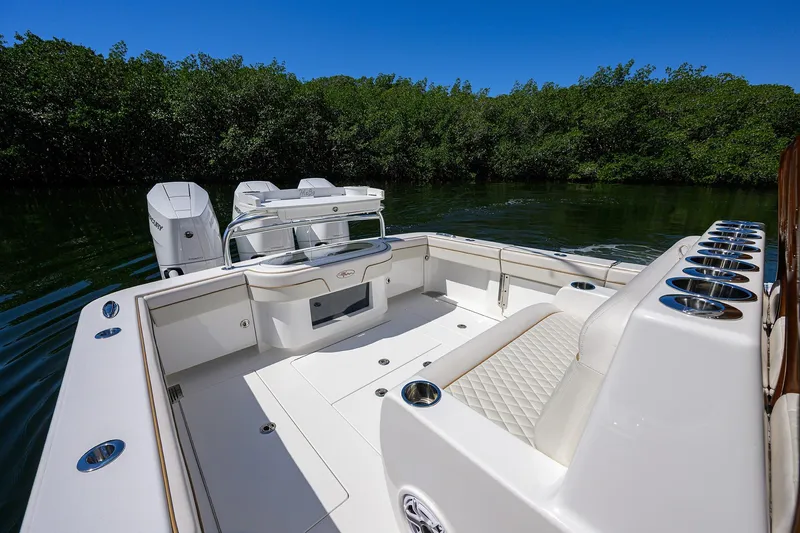 Slide: The Image of 2025 Valhalla V-37 boat interior with seating and cup holders, surrounded by lush greenery. - 31