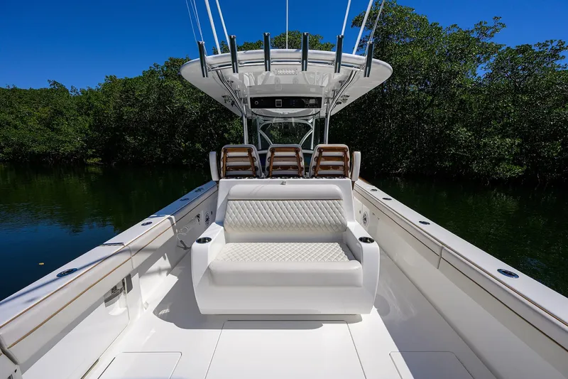 Slide: The Image of 2025 Valhalla V-37 boat interior with luxurious seating, surrounded by lush greenery. - 36