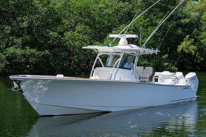 Slide: The Image of 2025 Valhalla V-37 boat cruising on a serene waterway surrounded by lush greenery. - 4