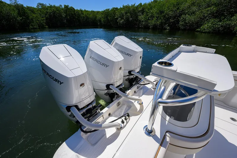 Slide: The Image of Triple Mercury outboard engines on a 2025 Valhalla V-37 boat in a serene waterway. - 47