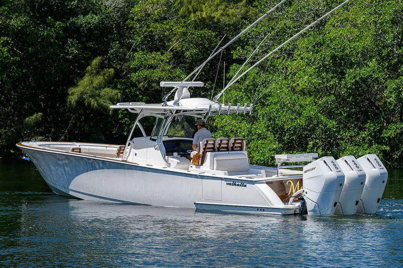 Slide: The Image of 2025 Valhalla V-37 boat with triple Mercury engines on a serene waterway. - 8