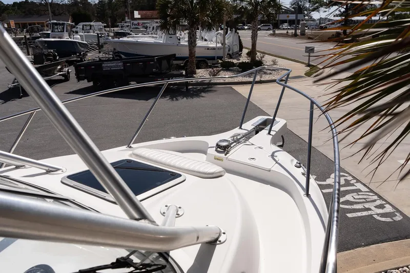 Slide: The Image of 2005 Boston Whaler 235 Conquest boat docked at a marina, surrounded by other vessels. - 14
