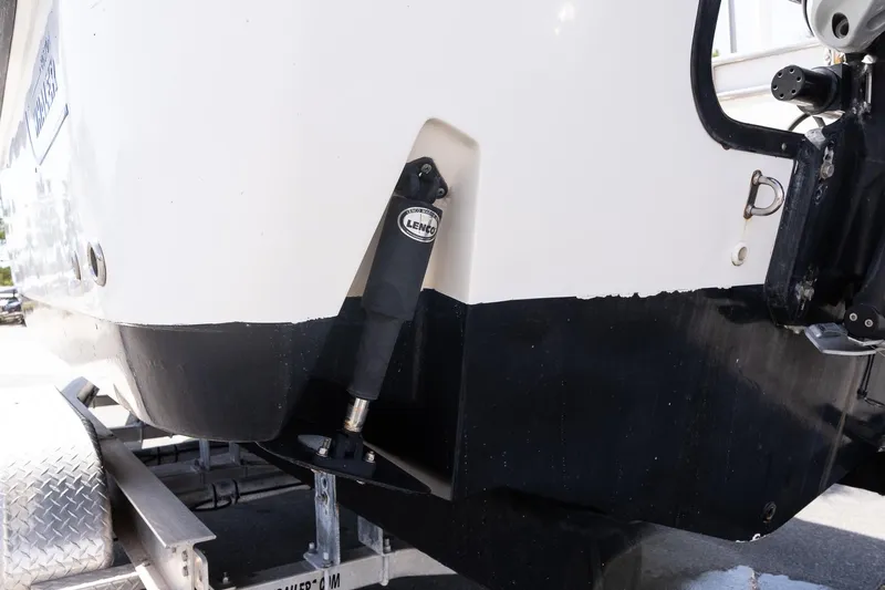 Slide: The Image of 2005 Boston Whaler 235 Conquest boat on trailer, showing hull and trim tab detail. - 18