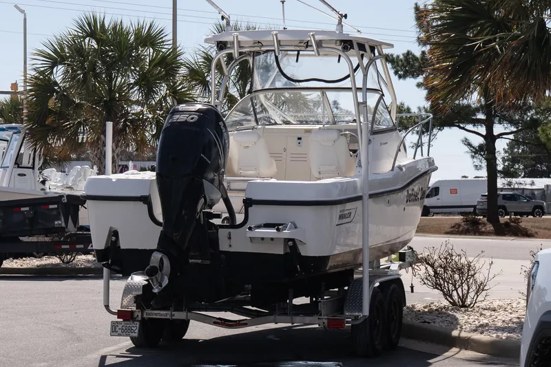 Slide: The Image of 2005 Boston Whaler 235 Conquest boat on trailer, parked outdoors. - 7