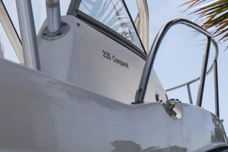 Slide: The Image of 2005 Boston Whaler 235 Conquest boat, close-up view with railing and clear sky. - 8