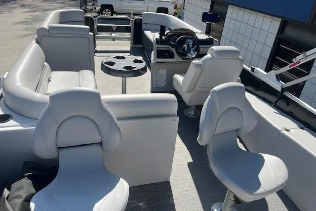 Slide: The Image of 2023 Godfrey Sweetwater 2286 FS pontoon boat interior with plush seating and steering console. - 18