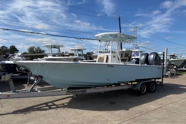 The Image of 2022 Tidewater 2700 Carolina Bay boat on trailer, parked outdoors under blue sky. - 1