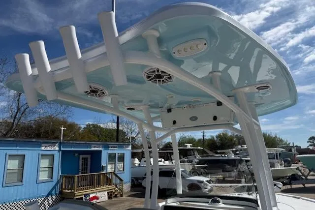 Slide: The Image of Tidewater 2700 Carolina Bay 2022 boat with T-top and rod holders, docked under blue sky. - 11