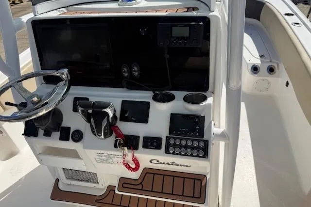 Slide: The Image of 2022 Tidewater 2700 Carolina Bay boat console with steering wheel and navigation controls. - 12