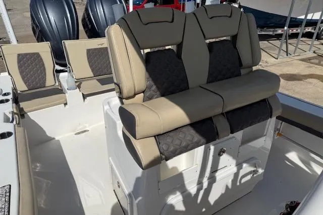 Slide: The Image of 2022 Tidewater 2700 Carolina Bay boat interior with cushioned seating and dual engines. - 13