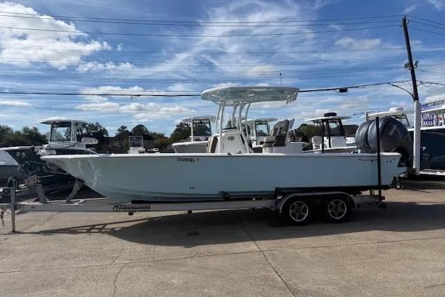 Slide: The Image of 2022 Tidewater 2700 Carolina Bay boat on trailer under blue sky. - 2