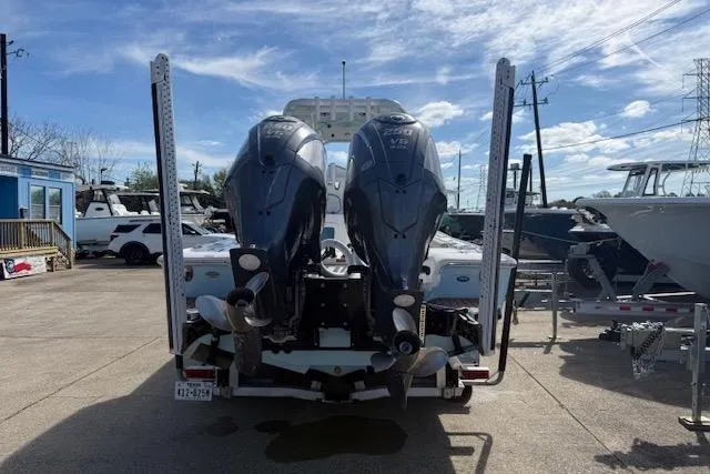 Slide: The Image of 2022 Tidewater 2700 Carolina Bay boat with dual outboard motors in a marina setting. - 4
