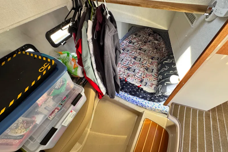 Slide: The Image of Cozy cabin interior of 2019 Ranger Tugs R-31 CB with bed, storage, and hanging clothes. - 26