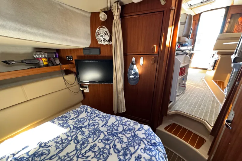 Slide: The Image of 2019 Ranger Tugs R-31 CB cabin interior with bed, TV, and wooden cabinetry. - 28