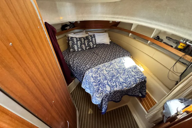 Slide: The Image of Cozy cabin interior of 2019 Ranger Tugs R-31 CB with patterned bedding and wooden accents. - 30