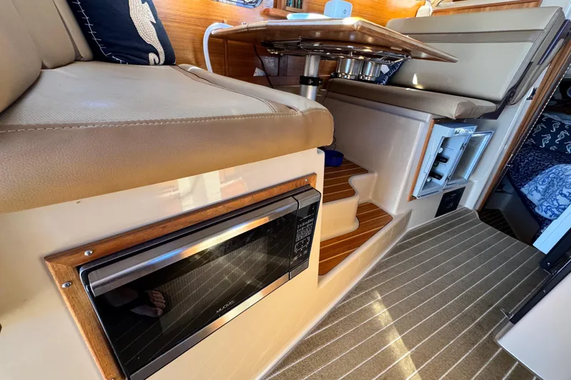 Slide: The Image of Interior of 2019 Ranger Tugs R-31 CB with seating, microwave, and steps. - 34