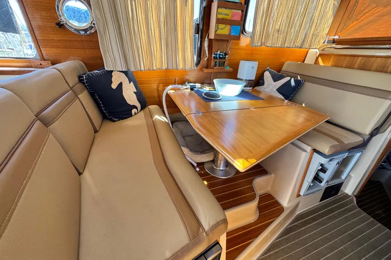 Slide: The Image of Interior of 2019 Ranger Tugs R-31 CB with cozy seating and wooden table. - 35