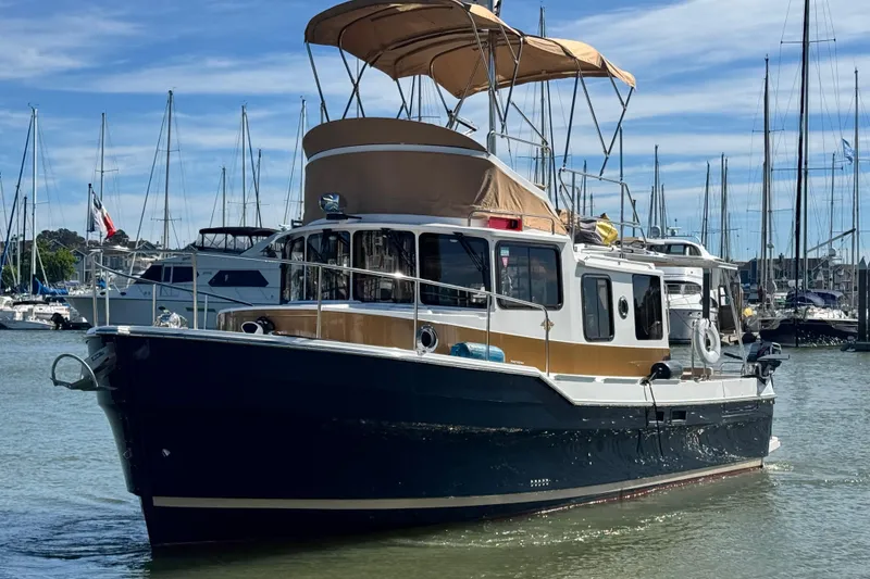 Slide: The Image of 2019 Ranger Tugs R-31 CB boat docked in marina, surrounded by sailboats. - 39