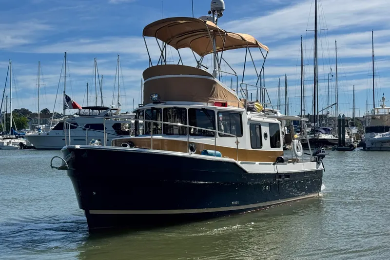 Slide: The Image of 2019 Ranger Tugs R-31 CB boat docked in a marina with sailboats. - 40