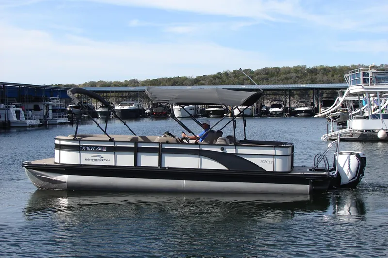 The Image of 2019 Bennington SX 25 SCWXP pontoon boat cruising on a calm lake. - 0