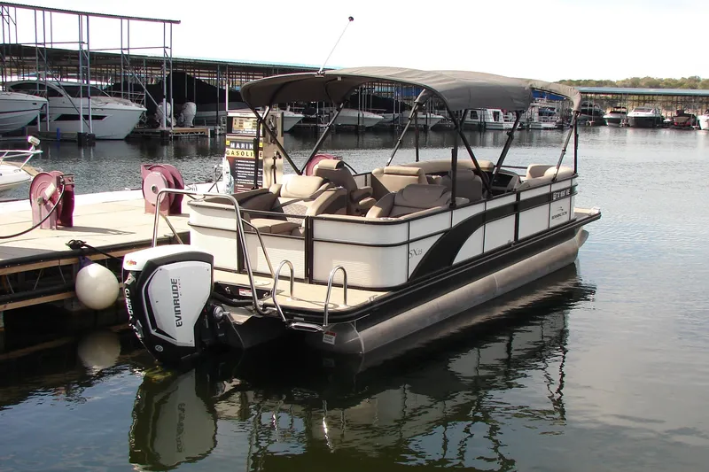 Slide: The Image of 2019 Bennington SX 25 SCWXP pontoon boat docked at marina with Evinrude engine. - 11
