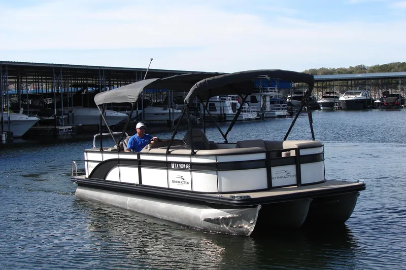 Slide: The Image of 2019 Bennington SX 25 SCWXP pontoon boat cruising on a calm lake. - 3