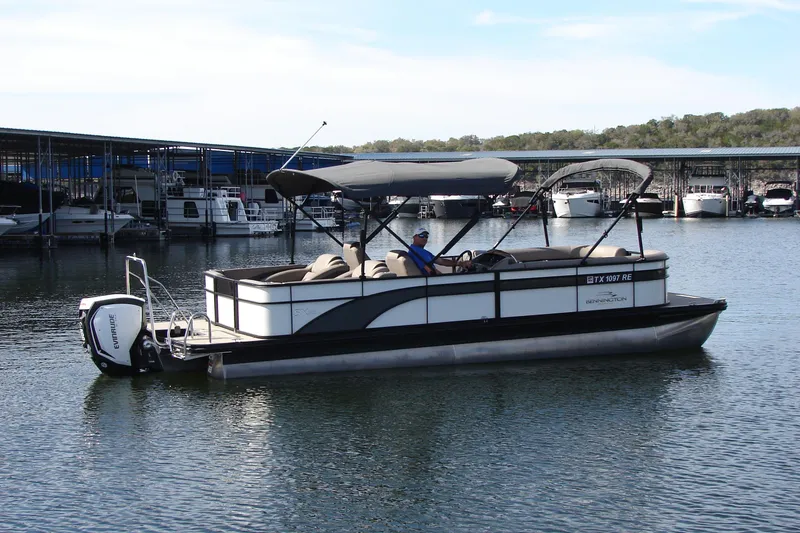 Slide: The Image of 2019 Bennington SX 25 SCWXP pontoon boat on a calm lake near a marina. - 4