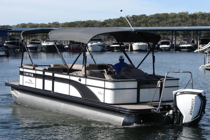 Slide: The Image of 2019 Bennington SX 25 SCWXP pontoon boat cruising on a lake with canopy. - 6