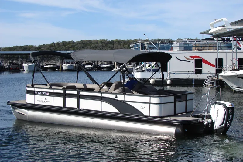 Slide: The Image of 2019 Bennington SX 25 SCWXP pontoon boat on a calm lake. - 7