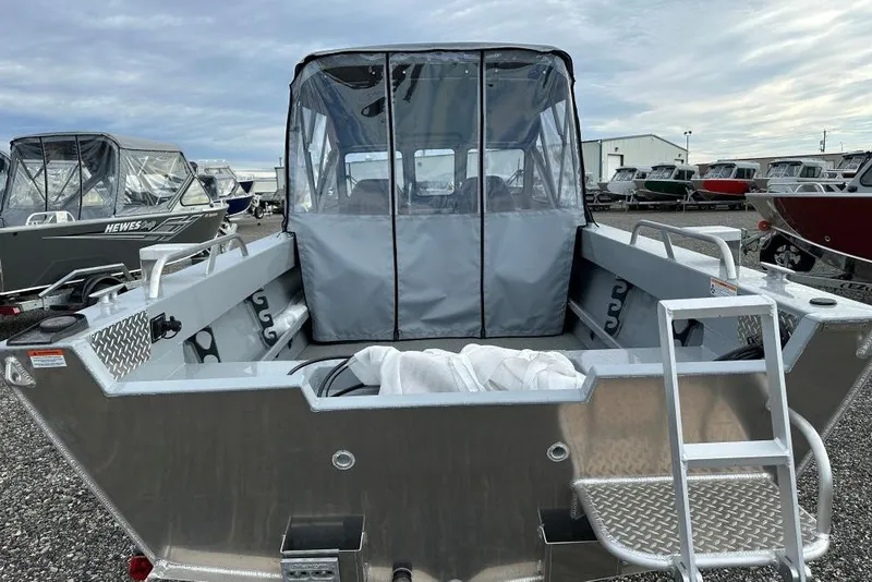 Slide: The Image of 2026 Hewescraft 200 Sportsman boat with covered cabin, displayed outdoors. - 3
