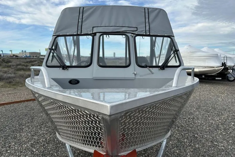 Slide: The Image of 2026 Hewescraft 200 Sportsman boat with aluminum hull and canopy, parked outdoors. - 4